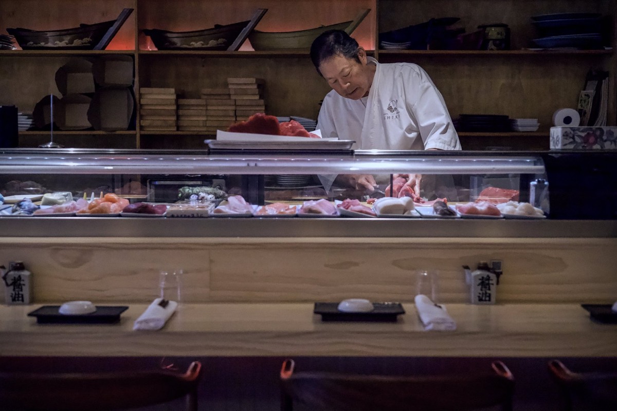 A sushi chef preparing a dish at Shiki’s counter
