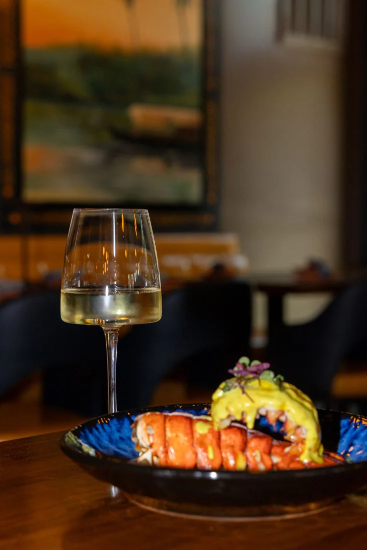 Wine and a plated dish at Rivayat